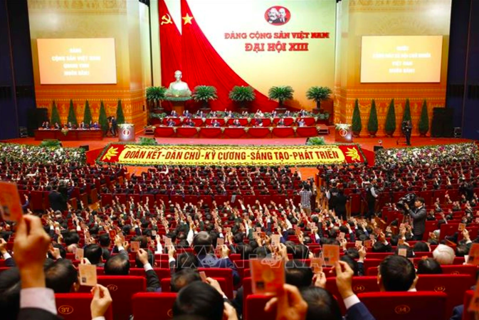 Các đại biểu biểu quyết, thông qua Nghị quyết Đại hội XIII Đảng Cộng sản Việt Nam. (Ảnh: TTXVN)