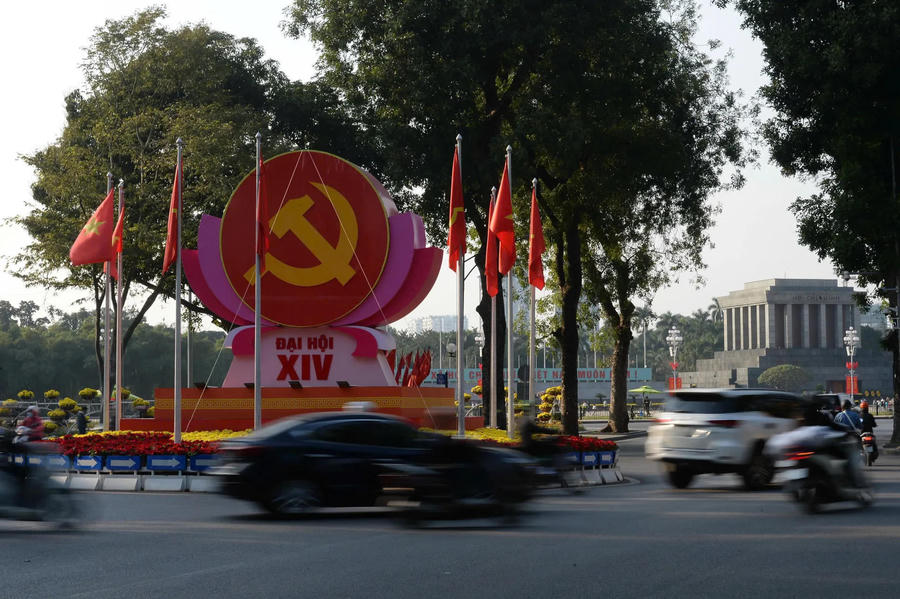 Party flags and national flags fly side by side along major arteries, their symmetry signaling both continuity and collective resolve.