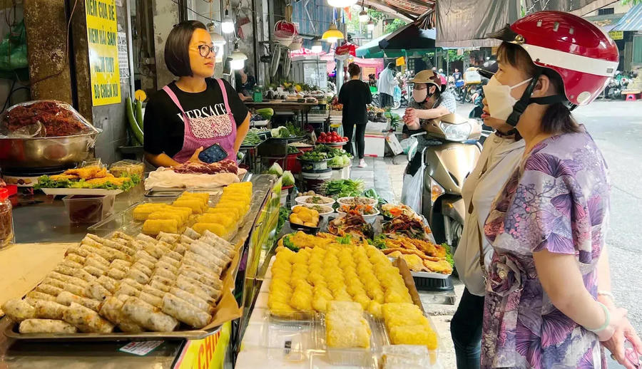 People buy foods at a makeshift market on Hang Be Street. Photo: Hoai Nam/The Hanoi Times