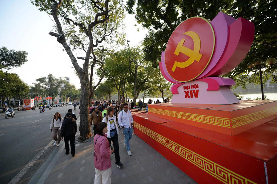 Hình ảnh 4 Around Hoan Kiem Lake, one of the city’s most enduring civic spaces, the red of the national flag contrasts sharply with the pastel tones of early spring blossoms.