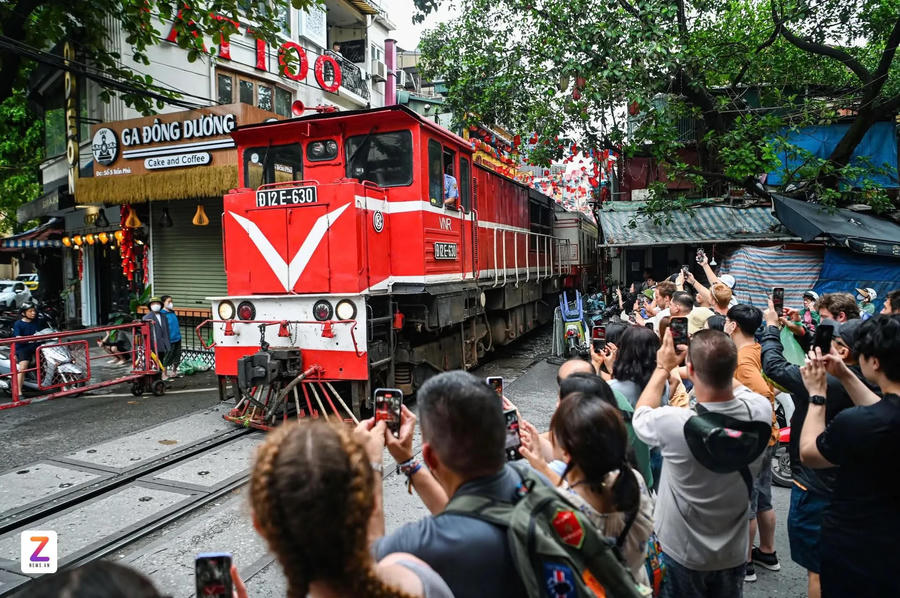 Tourists crowd the trackside, cameras raised, whenever a train passes Hanoi Railway Cafe Street. Photo: Penci Black