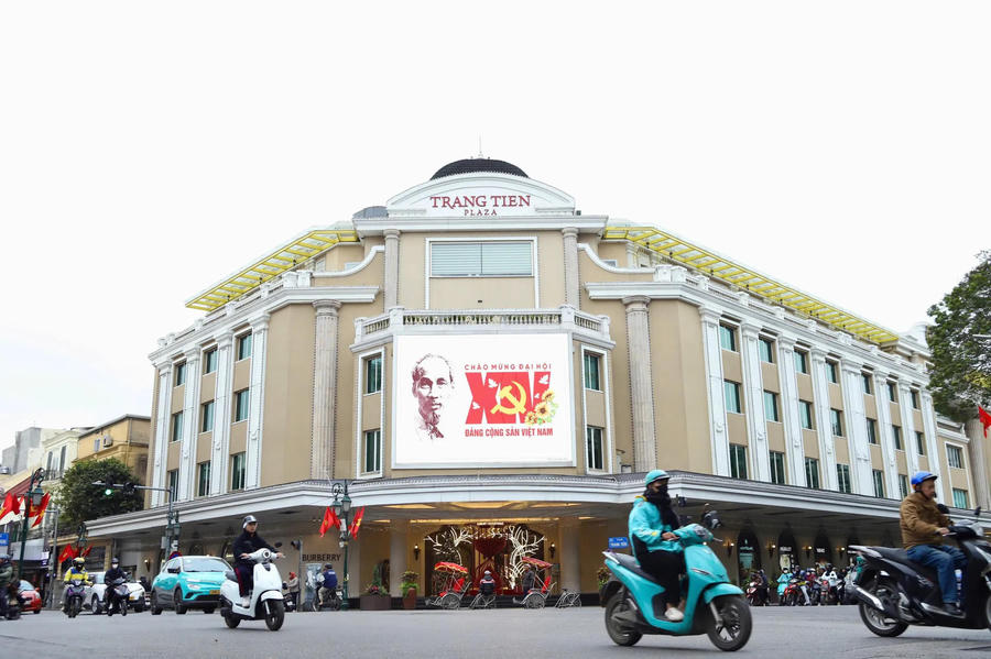 A LED screen outside a Trang Tien Plaza in Hanoi’s downtown displays the hammer-and-sickle emblem, extending the congress’s presence into places of consumption and leisure.