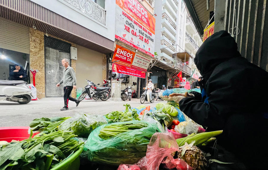Le Thanh Hung sits by his groceries at a makeshift market on Phao Dai Lang Street. Photo: Dan Viet Newspaper