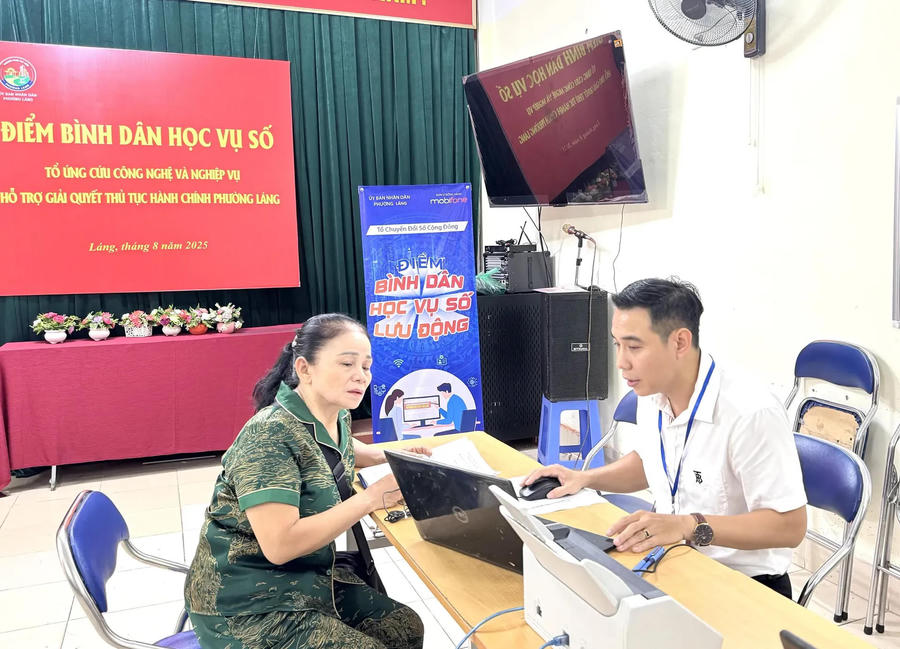 An official in Lang Ward, Hanoi guides a local resident how to get online building permit.