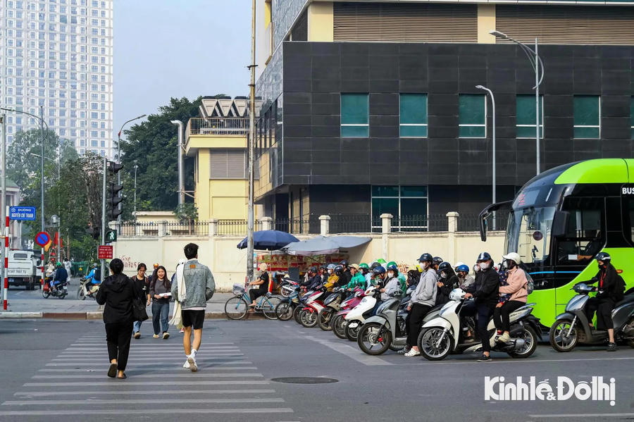 Hình ảnh 3 People crosses an intersection in Hanoi while vehicles wait for the light to turn green. Photo: Duy Minh/The Hanoi Times