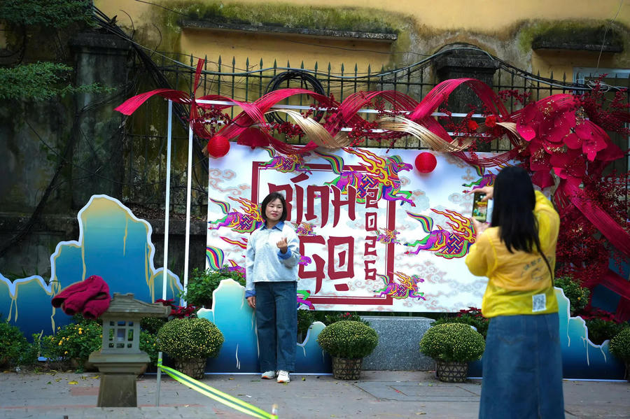 A tourist poses for photos at a brightly decorated display celebrating Vietnam’s traditional Lunar New Year in Hanoi. Photo: Duy Khanh/ The Hanoi Times