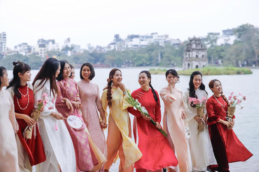 Women in traditional ao dai pose for photos during Lunar New Year celebrations at Hoan Kiem Lake. Photo: Duy Minh/ The Hanoi Times