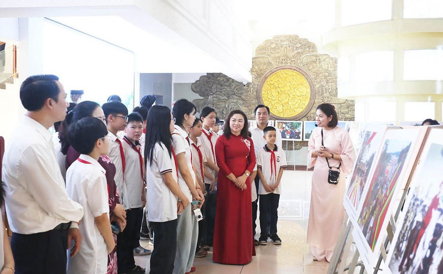 Các đại biểu và học sinh tham quan, tìm hiểu về các hình ảnh, tài liệu, hiện vật tại Bảo tàng Hùng Vương.