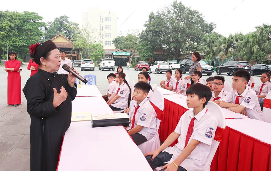 Hoạt động giao lưu, trò chuyện giữa Nghệ nhân Nhân dân Nguyễn Thị Lịch và các em học sinh.