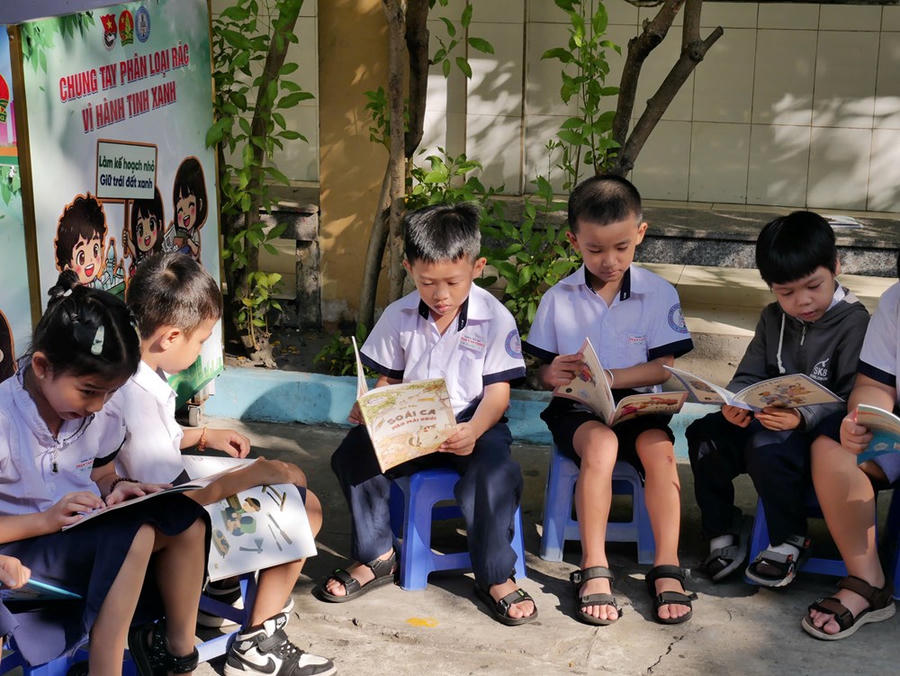 Các em học sinh chăm chú đọc sách tại "thư viện di động"
