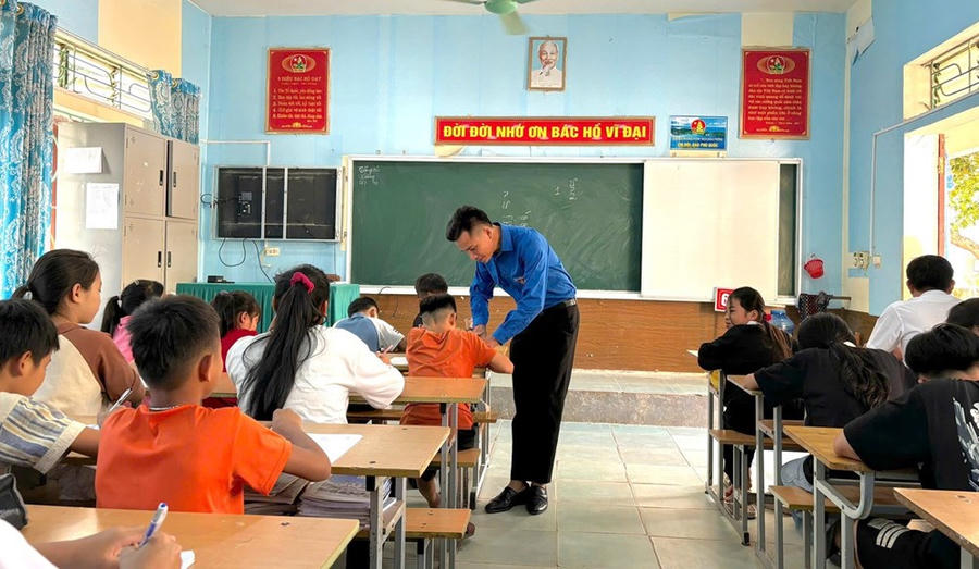 Bí thư Đoàn xã Lữ Thành Đức hướng dẫn học sinh viết chữ Thái trong lớp học cộng đồng