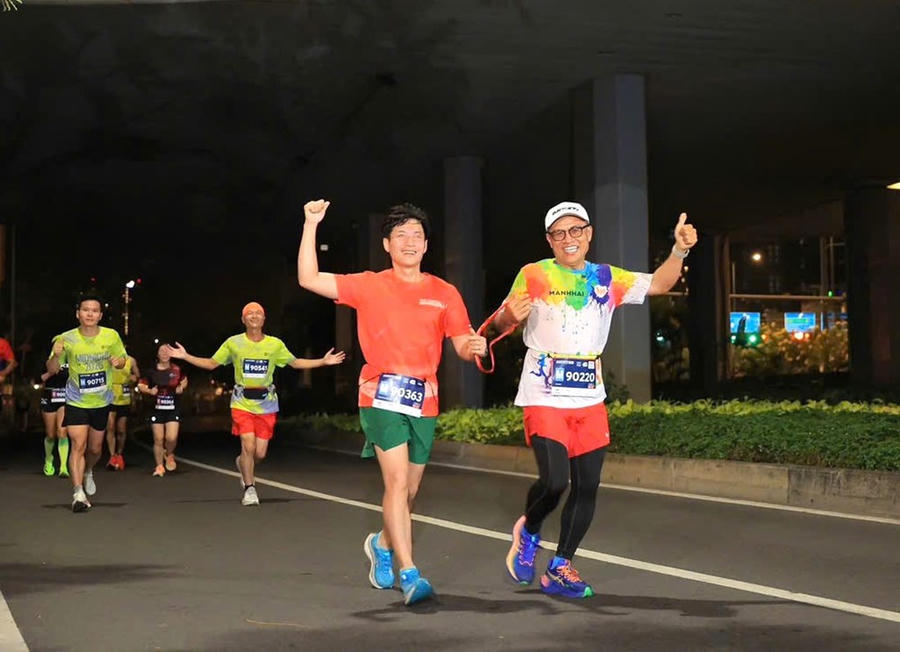 Anh Huỳnh Hữu Cảnh (áo cam) cùng người đồng hành tại một giải chạy