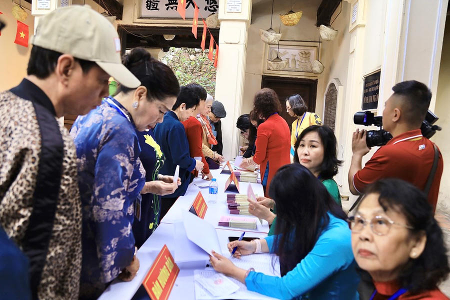 Các cử tri phường Hoàn Kiếm xếp hàng tại bàn tiếp đón để kiểm tra danh sách và nhận phiếu bầu trước khi vào khu vực viết phiếu. Đại diện tổ bầu cử cho biết các khâu chuẩn bị, từ kiểm tra danh sách cử tri, phát phiếu đến hướng dẫn quy trình bỏ phiếu, đã được triển khai đầy đủ nhằm bảo đảm quá trình bầu cử diễn ra đúng quy định, thuận lợi và an toàn cho người dân