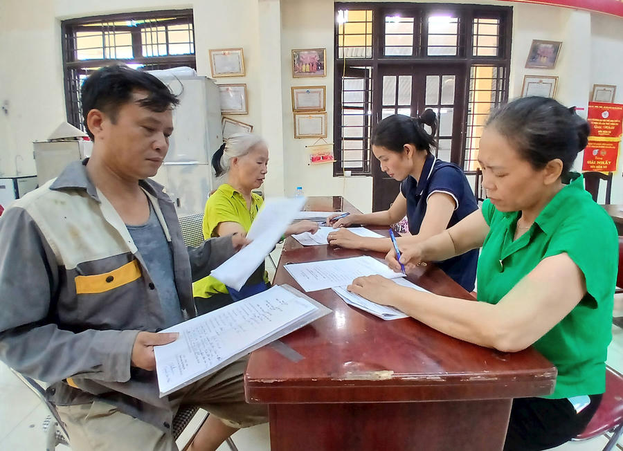 Người dân thôn Lạc Thị mang giấy tờ đến nhập dữ liệu. Ảnh: Hoàng Quyết