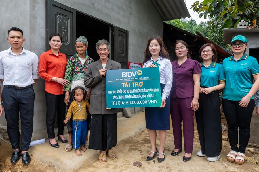 Bà Nguyễn Thị Liên Phương, Phó Giám đốc BIDV chi nhánh Yên Bái (thứ tư bên phải) trao nhà mới cho gia đình ông Giàng Vảng Dinh (áo vest ghi). Ảnh: Việt Linh